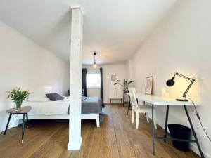 a bedroom with a bed and a desk and a table at Two-story Old Town Apartment in Toruń
