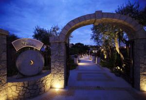 a stone archway with a sign on a fence at Hotel Al Mulino in Anacapri