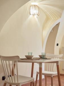 mesa de comedor con 2 sillas y lámpara de araña en Blu Bari en Bari