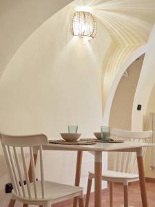 a dining room table with two chairs and a chandelier at Blu Bari in Bari