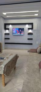 a living room with a couch and a tv on a wall at Hay salam réservé aux familles in Agadir