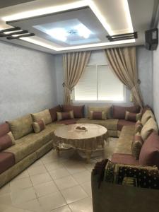 a living room with a couch and a table at Hay salam réservé aux familles in Agadir