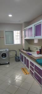 a kitchen with purple cabinets and a sink and a stove at Hay salam réservé aux familles in Agadir