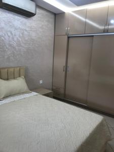 a bedroom with a bed and a large closet at Hay salam réservé aux familles in Agadir
