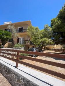 a wooden fence in front of a building at Santa Marina Rooms in Agia Marina Aegina