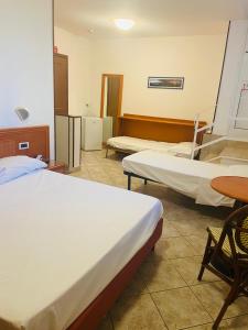Hotel Bella Riviera Lungomare في فياريجيو: غرفة مستشفى بسريرين وطاولة