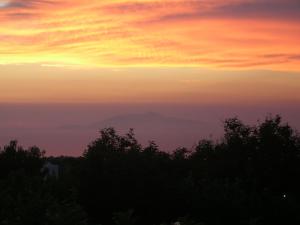 a sunset with a mountain in the distance at Hotel Al Mulino in Anacapri