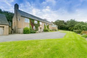 a house with a driveway and a grass yard at Cae'r Borth in Moelfre