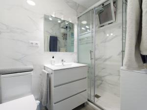 a white bathroom with a sink and a shower at Luxury Suite Over The Beach in Las Palmas de Gran Canaria