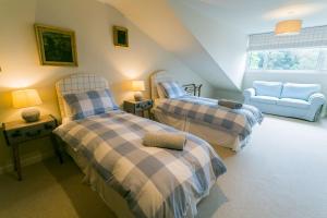 a bedroom with two beds and a couch at Cae'r Borth in Moelfre