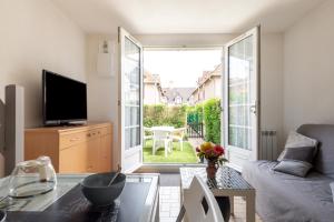 TV a/nebo společenská místnost v ubytování Le Regina Rifle - Appartement avec jardinet