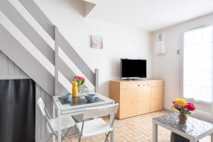 TV a/nebo společenská místnost v ubytování Le Regina Rifle - Appartement avec jardinet + 4 fotografie