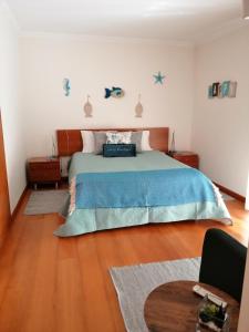 um quarto com uma cama com um cobertor azul em Casa da Pedralva em Nazaré