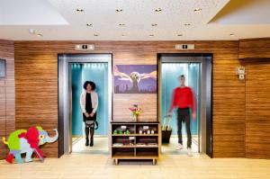Kobieta chodząca między dwoma szklanymi drzwiami w centrum handlowym w obiekcie Ibis Styles Wien City w Wiedniu +37 zdjęć