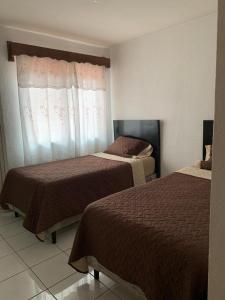 Habitación de hotel con 2 camas y ventana en Casa a 5 minutos de los parques del IRTRA, en Pucá