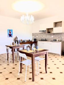 a kitchen with wooden tables and white chairs at B&B AcquaViva in Marina San Vito