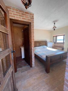 a bedroom with a bed and a brick wall at Beachfront villa Kakrc in Tivat