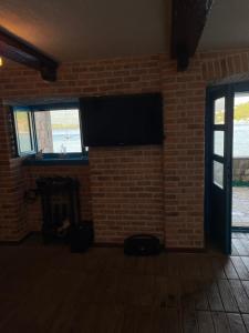 a living room with a brick wall and a flat screen tv at Beachfront villa Kakrc in Tivat
