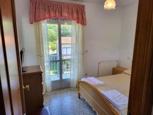 a small bedroom with a bed and a window at HOSTAL BARCELONA in Entrimo