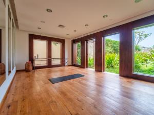 una stanza vuota con un tappetino da yoga su un pavimento in legno di Celeste Beach Residences Huatulco Curamoria Collection a Santa Cruz Huatulco
