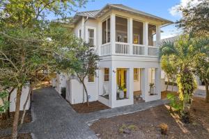 una casa bianca con portico e alberi di Ocean Serenade a Rosemary Beach