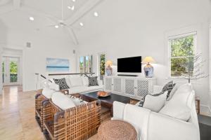 un soggiorno con mobili bianchi e TV a schermo piatto di Ocean Serenade a Rosemary Beach