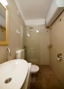 a bathroom with a sink and a toilet and a shower at Brna Three-room apartment near the beach-Zen in Brna