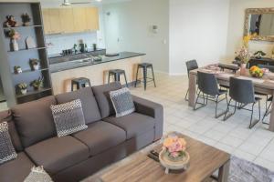 a living room and kitchen with a couch and a table at Top End Marvel -Darwin's Premier 3-BR Luxury Apt in Darwin
