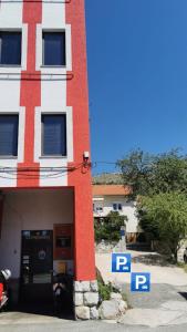 a red and white building with parking signs in front of it at Jasmina in Senj