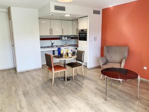 a living room with a table and chairs and a kitchen at Appart One Le Cannet in Le Cannet