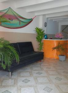 un sofá negro en una sala de estar con macetas en Rivera Hostel, en Santa Marta