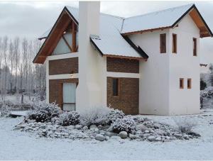 una casa con la neve per terra davanti di Cabañas La Ufu a Golondrinas