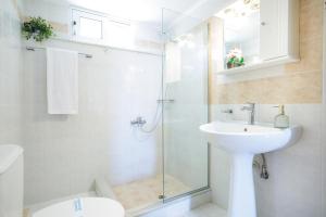 a bathroom with a sink and a glass shower at La Pietra Verga in Kalamata +59 photos