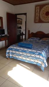 sypialnia z łóżkiem z niebieskim kocem w obiekcie Casa Temporada Clebinho w mieście Tiradentes