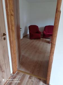 a mirror reflection of a room with two red chairs at Apartmány u Bečova nad Teplou in Bečov nad Teplou