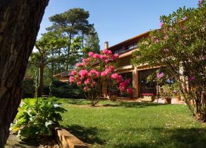 une maison avec des fleurs roses dans la cour dans l'établissement Résidence Hôtelière les Acanthes, à Hossegor