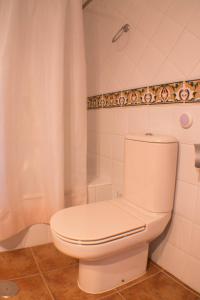 uma casa de banho com um WC branco e um chuveiro em PRECIOSO APARTAMENTO EN PRIMERA LÍNEA DE PLAYA em Isla Canela