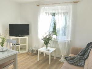 a living room with a couch and a tv and a window at Haus Heimatliebe in Obernheim