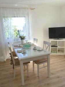 a dining room table with chairs and a television at Haus Heimatliebe in Obernheim