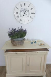 a clock on the wall above a table with a plant at Haus Heimatliebe in Obernheim