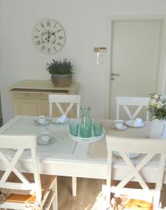 a white table with two chairs and a clock at Haus Heimatliebe in Obernheim
