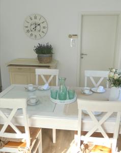 a white table with two chairs and a clock at Haus Heimatliebe in Obernheim