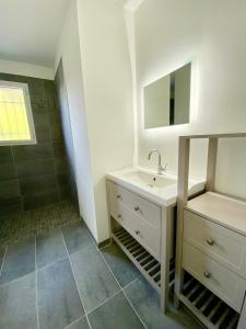 a white bathroom with a sink and a mirror at Magnifique villa avec piscine in Escource