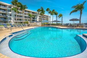 a large blue swimming pool with palm trees and a building at Bahia Vista 8-314, 2 Bedroom, Heated Pool, Spa, WiFi, Sleeps 6 in St. Petersburg