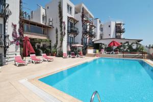 a swimming pool in front of a building at Gumbet Hotel in Gümbet