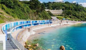 a view of a beach with blue water and a bridge at Lovely Villa 3 king 1 double 1 double sofa 1 bunk in Torquay