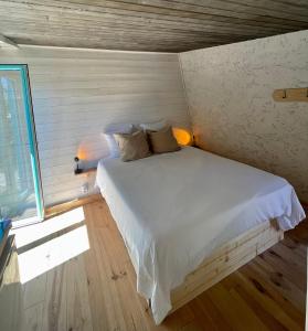 um quarto com uma cama branca num quarto com uma janela em Little California - Adorable Studio Indépendant em Cagnes-sur-Mer