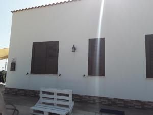 a white wall with three windows and a chair at La Campagnola in Locogrande