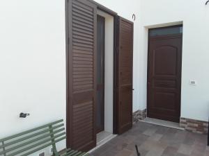 une paire de portes dans une pièce avec un banc dans l'établissement La Campagnola, à Locogrande