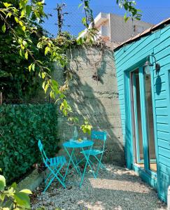 2 sillas y una mesa frente a un edificio azul en Little California - Adorable Studio Indépendant en Cagnes-sur-Mer